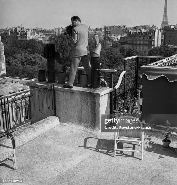 Caméraman sur un toit falais Rose de l'avenue Foch à Paris, le 17 juin 1949.