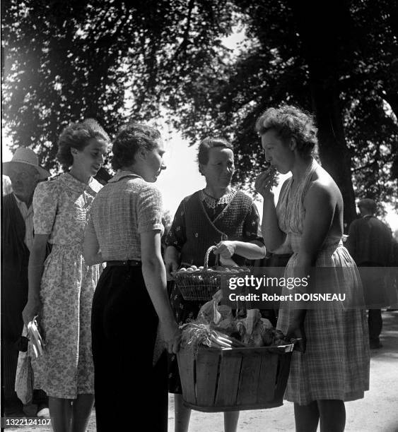Groupe de femmes avec un cageot de légumes et un panier Carennac France.
