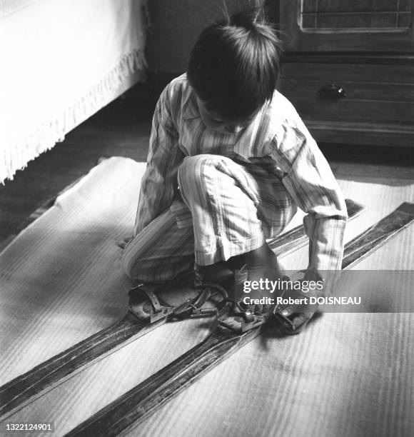 Un enfant en pyjama essaie ses skis dans une chambre à Mege?ve en 1936.