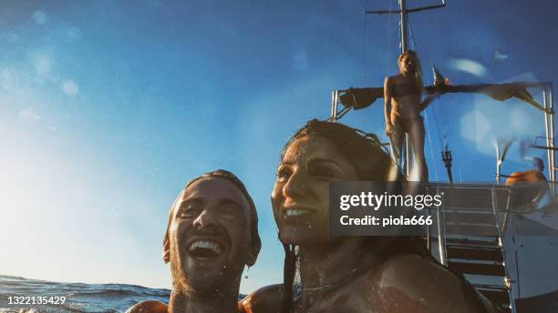 sommerurlaub: freunde tauchen von einem segelboot auf see - camera boat stock-fotos und bilder