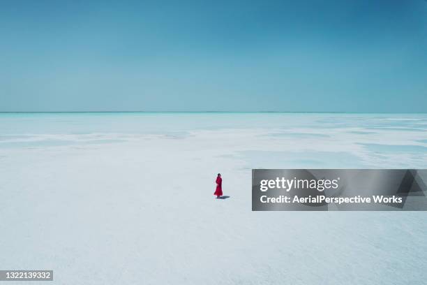 woman wearing red dress walking on salt lake - green dress stock pictures, royalty-free photos & images