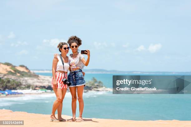 mamma och hennes tonårsdotter tar ett jag på stranden - beach selfie bildbanksfoton och bilder