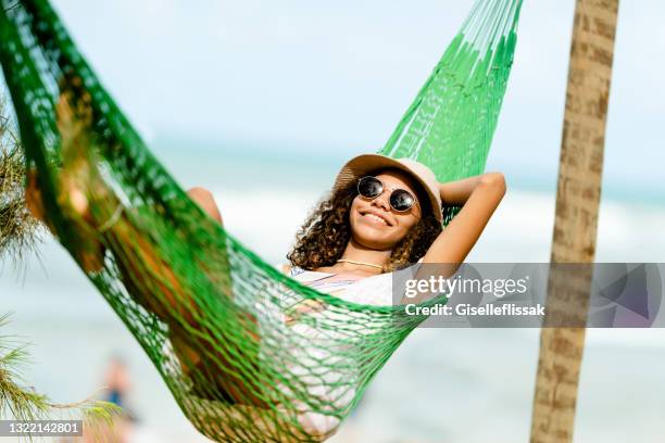 giovane donna che si rilassa su un'amaca in spiaggia - young teen girl beach foto e immagini stock
