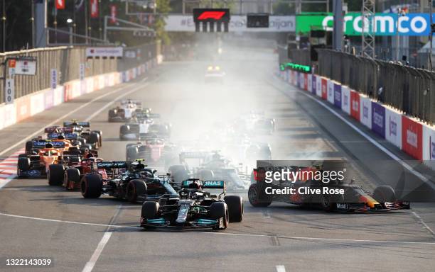 Lewis Hamilton of Great Britain driving the Mercedes AMG Petronas F1 Team Mercedes W12 locks up under pressure from Sergio Perez of Mexico driving...
