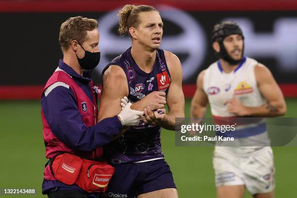 Nat Fyfe of the Dockers is assisted from the field with a shoulder injury during the round 12 AFL match between the Fremantle Dockers and the Western...