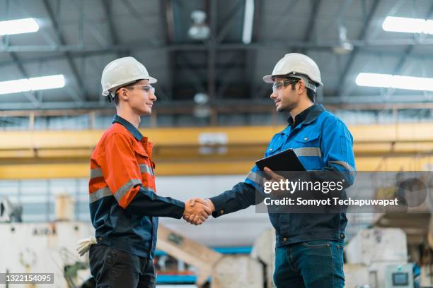 hand shake greeting of professional  engineer teamwork in factory - foundations conversations with suits stock-fotos und bilder