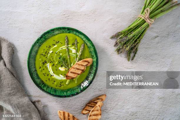 asparagus soup plate with ingredients and bread toasts on white cement - tableware stock pictures, royalty-free photos & images