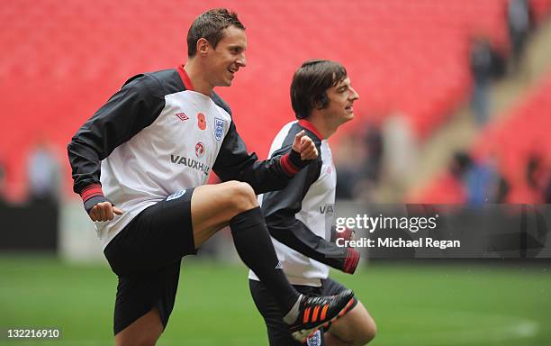 Phil Jagielka of England warms up with Leighton Baines during their training session at Wembley Stadium on November 11, 2011 in London, England.