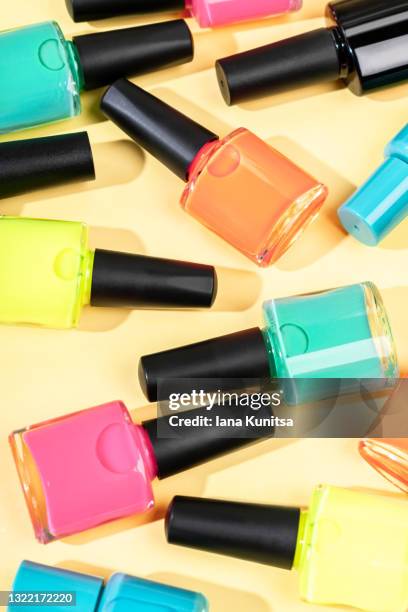 bright multi-colored nail polishes on trendy yellow background. summer vertical banner. - fingernail stock photos et images de collection