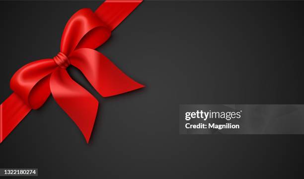 red gift bow with ribbon on a black background - black friday stock illustrations