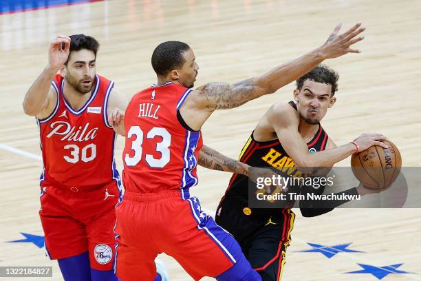 Trae Young of the Atlanta Hawks looks to pass past George Hill of the Philadelphia 76ers during the fourth quarter during Game One of the Eastern...