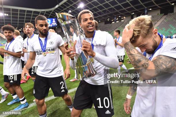 Lukas Nmecha of Germany celebrates with the UEFA European Under-21 Championship trophy following victory in the 2021 UEFA European Under-21...