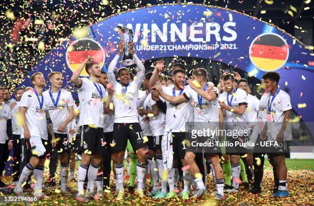 Lukas Nmecha of Germany lifts the UEFA European Under-21 Championship trophy in celebration with team mates after winning the 2021 UEFA European...