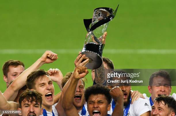 The Germany team lift the UEFA European Under-21 Championship trophy in celebration with team mates after winning the 2021 UEFA European Under-21...