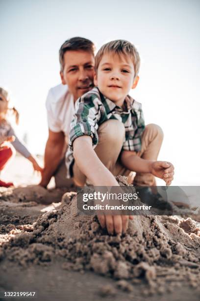 vader die met zonen in het strand speelt - father son water park stockfoto's en -beelden