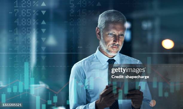 foto mejorada digitalmente de un guapo hombre de negocios usando una tableta superpuesta sobre un gráfico que muestra los altibajos del mercado de valores - certificado de una acción fotografías e imágenes de stock