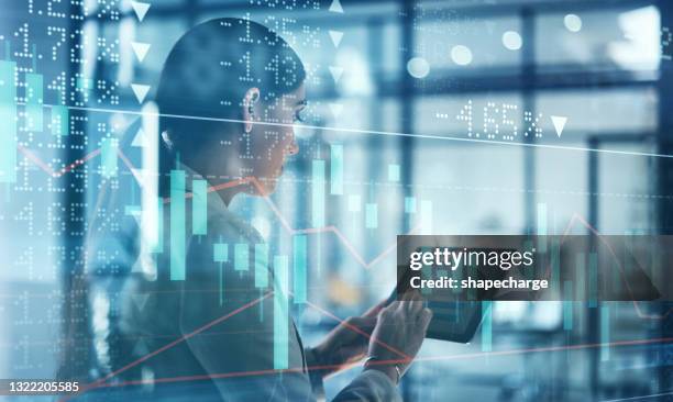 digitally enhanced shot of an attractive businesswoman using a tablet superimposed over a graph showing the ups and downs of the stock market - digital enhancement stock pictures, royalty-free photos & images