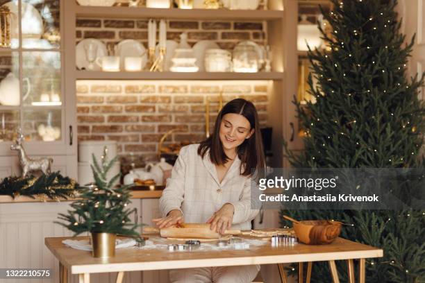 beautiful woman making holiday cookies at home. - flour christmas photos et images de collection