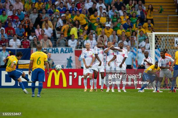 Juninho Pernambucano of Brazil takes a free kick against the wall of Zinedine Zidane, Patrick Vieira, Thierry Henry and Eric Abidal of France during...