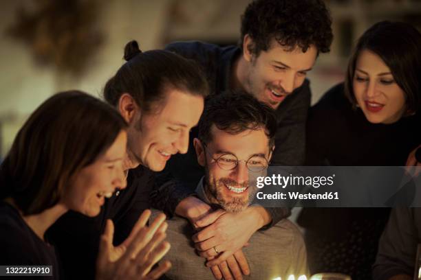 happy male and women celebrating friend's birthday at home - birthday surprise stock pictures, royalty-free photos & images