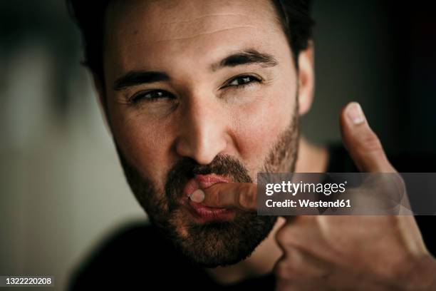 man licking index finger - the favourite film stock-fotos und bilder