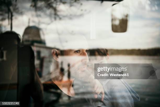 father and son seen through glass window - kid looking through window stock pictures, royalty-free photos & images