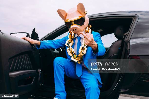 funny character wearing animal mask and blue business suit showing middle finger from car - middle finger funny 個照片及圖片檔