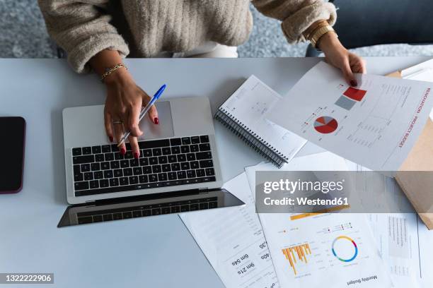 businesswoman using laptop while analyzing data at office - finanzbericht stock-fotos und bilder