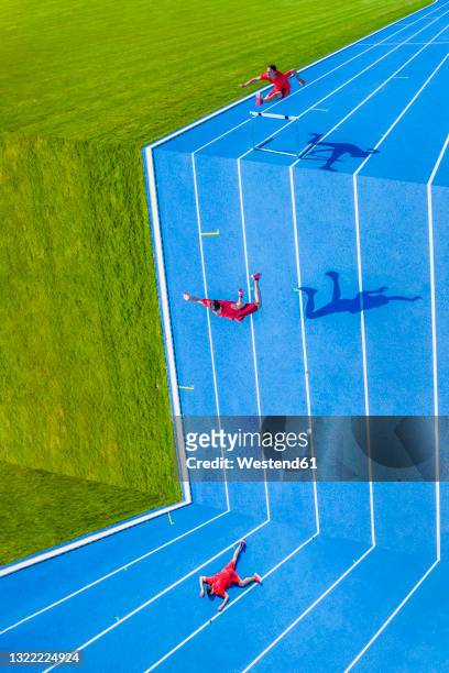 young man jumping over hurdle into abyss - nederlaag stockfoto's en -beelden