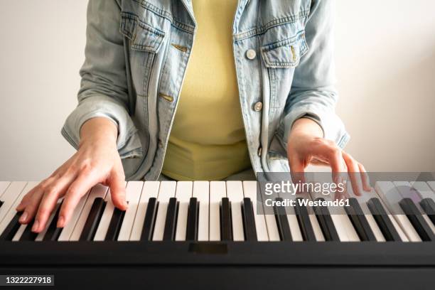 mid adult woman practicing piano at home - pianist front stock pictures, royalty-free photos & images
