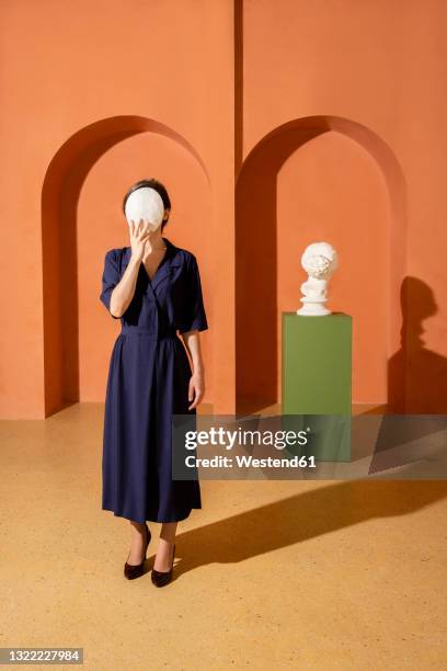 woman covering face with mask - surrealista foto e immagini stock