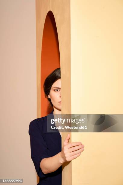 woman under arch on beige wall - stuck inside fotografías e imágenes de stock