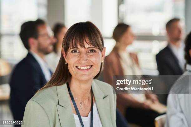smiling female entrepreneur with colleagues at educational event - variable schärfentiefe stock-fotos und bilder