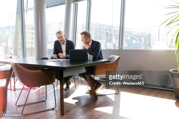 mature businessmen working at desk in office - business table stock-fotos und bilder