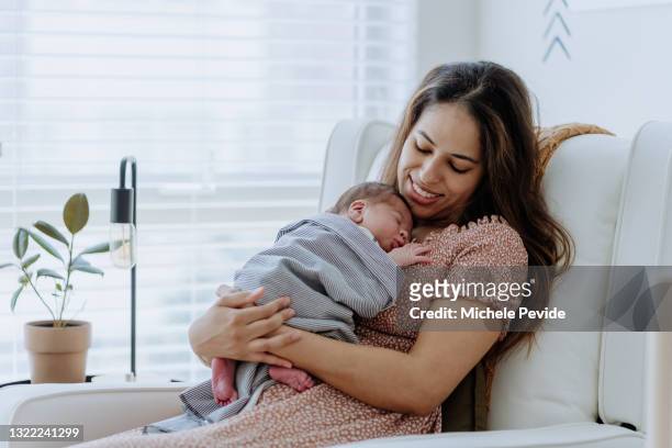 保育園で男の子を抱いた母親 - newborn ストックフォトと画像