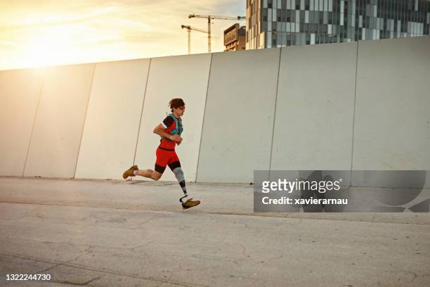early 30s sportsman with physical disability running outdoors - amputee running stock pictures, royalty-free photos & images