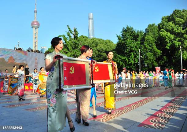 Women in cheongsams show the flags of the Communist Party of China during a cultural activity at Huangpu Park to celebrate the 100th anniversary of...