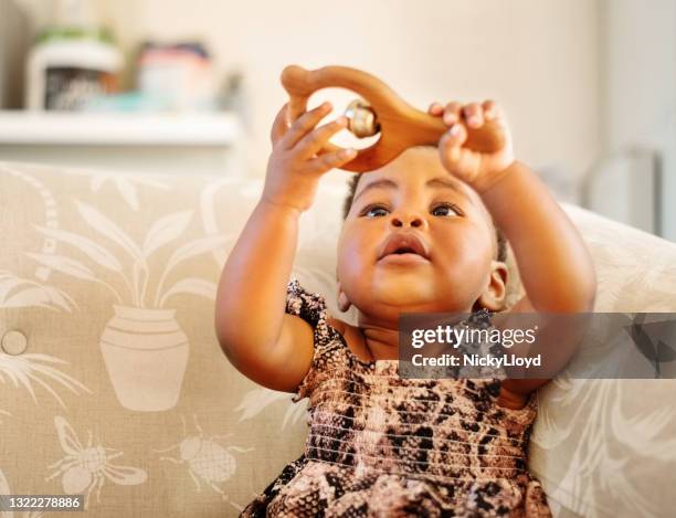 baby girl playing with rattler toy at home - africa game stock pictures, royalty-free photos & images