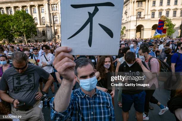 Protestor marches with a placard that reads "No" in Chinese during a demonstration against the planned construction of the Chinese Fudan University...