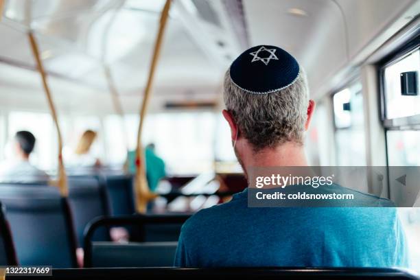 jüdischer mann trägt totenkopfmütze im bus in der stadt - orthodoxes judentum stock-fotos und bilder