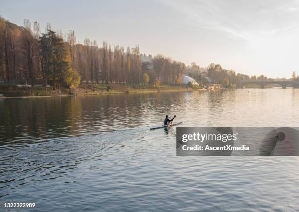 man paddles kayak along po river, turin - turino stock pictures, royalty-free photos & images