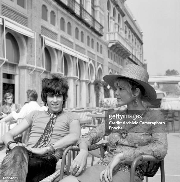 English musician Keith Richards with Anita Pallenberg, sitting outside the Excelsior Hotel, Lido, Venice, 1967.