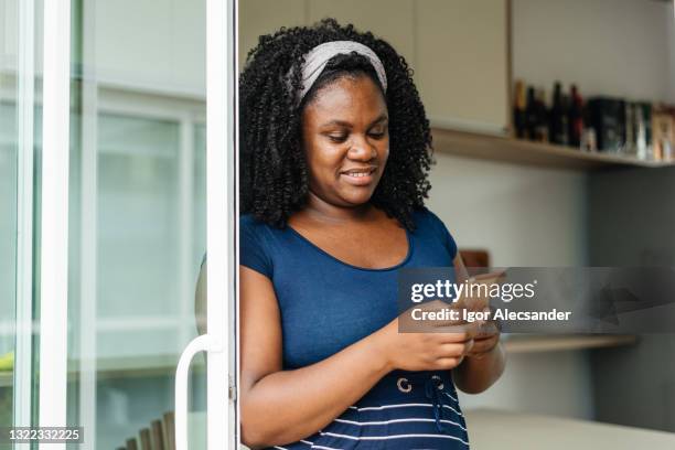 relaxed woman using smartphone at home - middle aged woman at home stock pictures, royalty-free photos & images