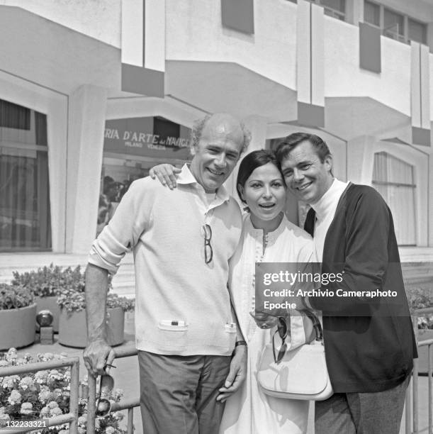 English actor Dirk Bogarde with movie director Jack Clayton and Israeli actress Haya Harareet outside the Movie Festival palace, Lido, Venice 1967.