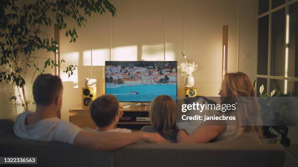 watching tv at home. family with two sons spending time together - guardians of heritage screening by german tv channel history stockfoto's en -beelden