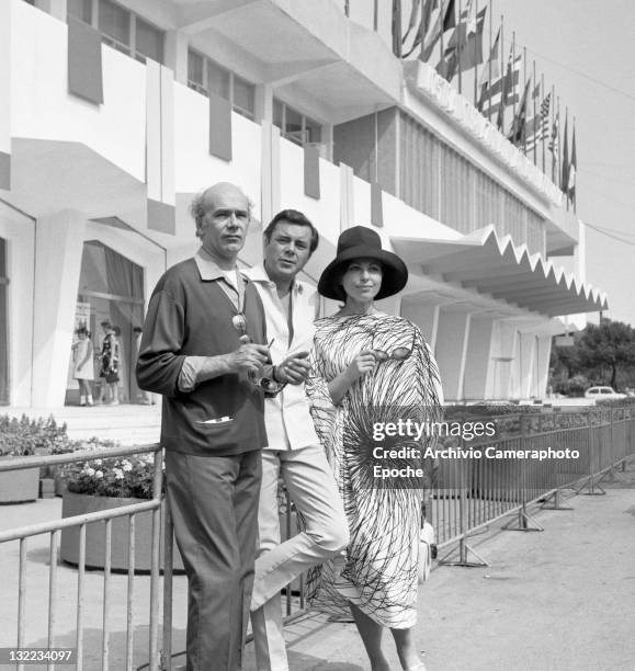 English actor Dirk Bogarde with movie director Jack Clayton and Israeli actress Haya Harareet outside the Movie Festival palace, Lido, Venice 1967.