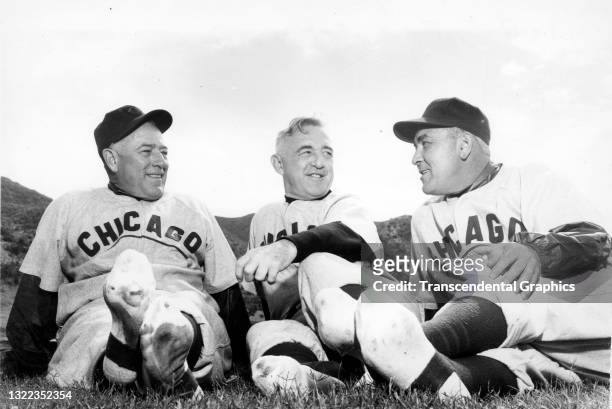 View of, from left, baseball coach Charlie Root, manager Frank Frisch, and coach Spud Davis, all of the Chicago Cubs, as they relax during spring...