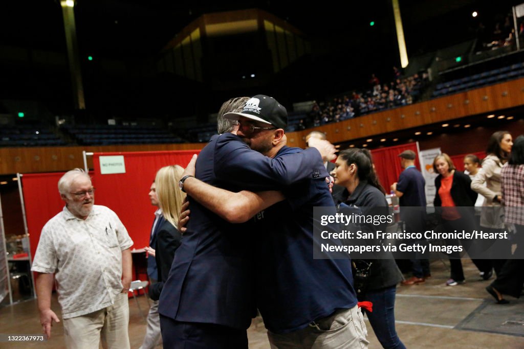 Governor Gavin Newsom (l to r) and Richard Oliva, Reading Glasses volunteer, hug after Oliva thanked Newsom for his support of housing for the homeless while Newsom toured  Project Homeless Connect at the Bill Graham Civic Auditorium on Wednesday, October