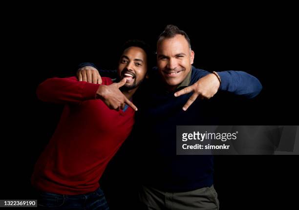 fröhliche männliche freunde zeigen handzeichen - african male red shirt stock-fotos und bilder