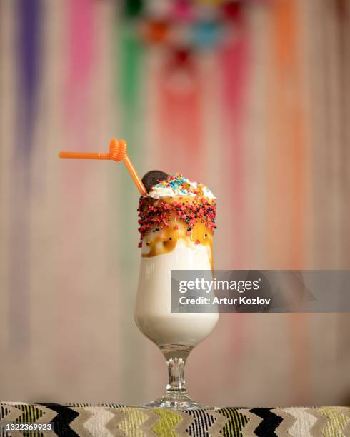 exotic refreshing milkshake drink in glass goblet. whipped milk and ice cream cocktail decorated with topping and straw on bar during party. summer dessert on vacation, rest or travel. soft focus - coffee variation stock pictures, royalty-free photos & images